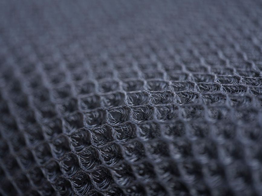 Detailed macro shot of a textured synthetic fabric with intricate patterns.
